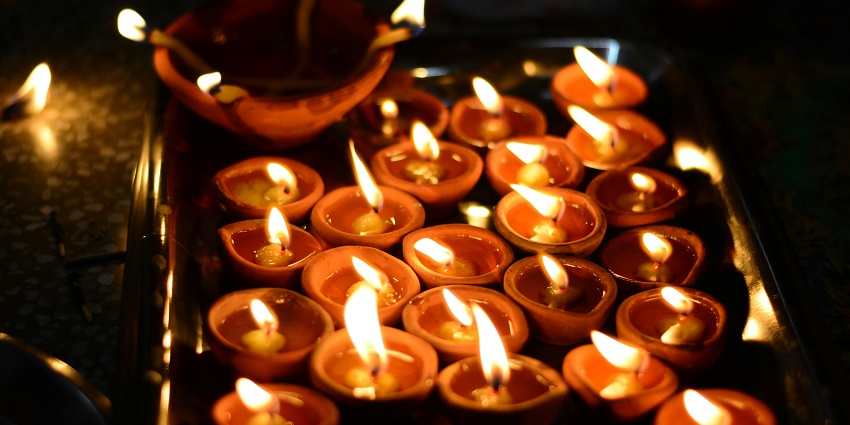 A closeup of multiple diyas lit up in a sacred site like Harshnath temple which is located in Rajasthan.