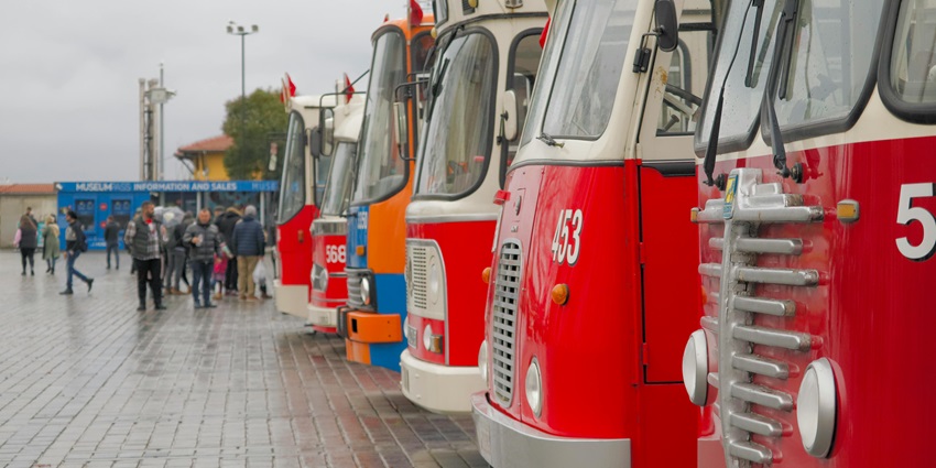 Image of colourful buses parked in a area during day time in a city area