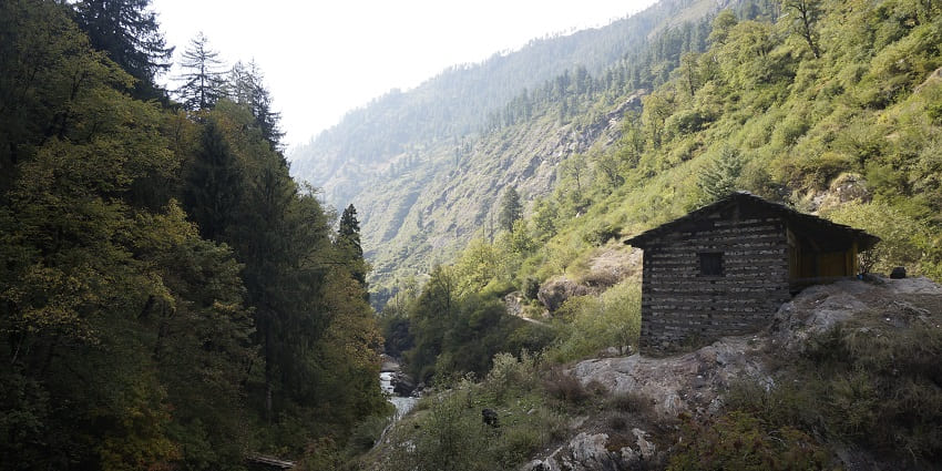 A picture of a small hut in the middle of wilderness of the Kheer Ganga trekking site