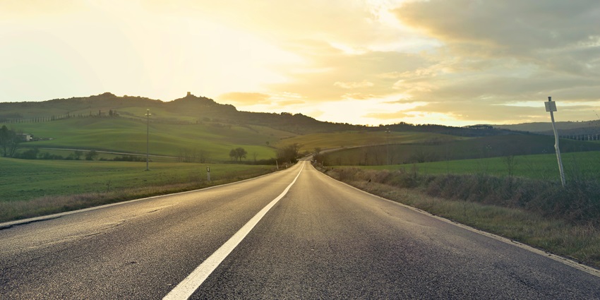 A stunning view of a winding road surrounded by lush greenery during the daytime.