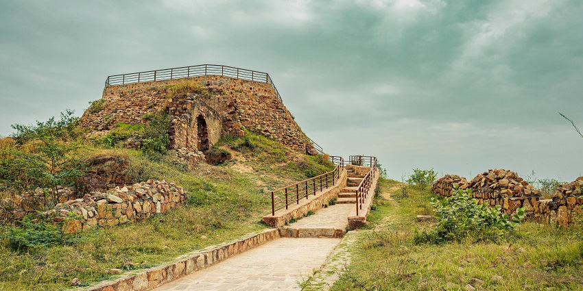A picture of a bridge in front of a fort with a canal passing under it