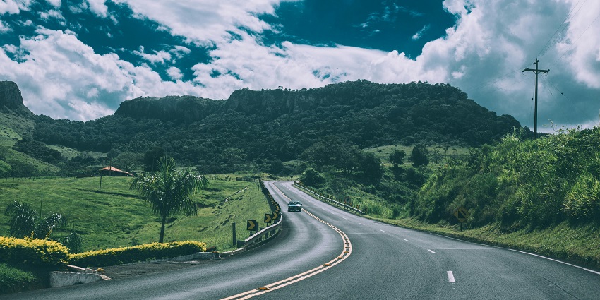A breathtaking view of a winding road with lush greenery all around it during the day.