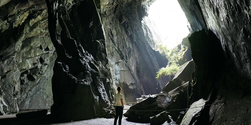 A tourist standing in the majestic halls of the caves