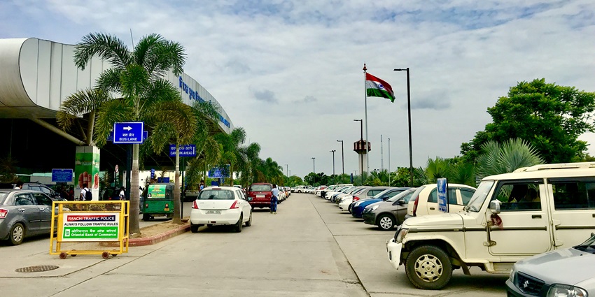 Car parking area near Birsa Munda Airport with vehicles parked and barricades in view