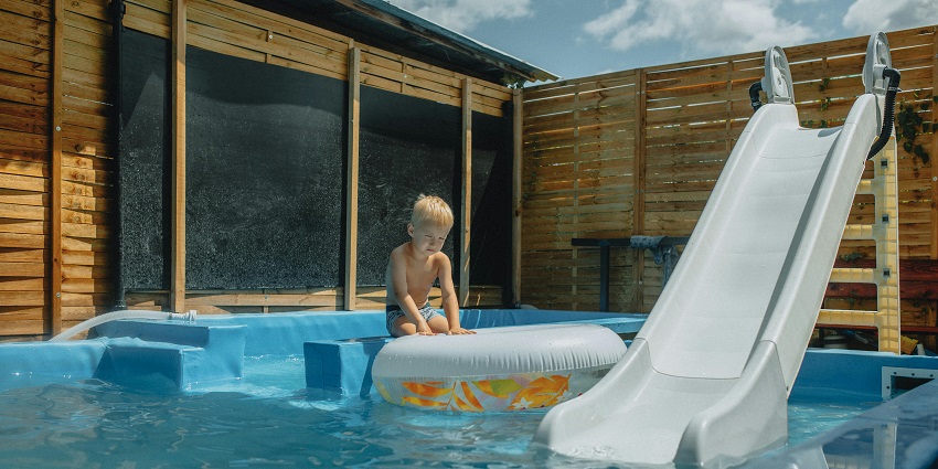 Happy child playing with a colourful inflatable reminiscent of Pink City Water Park.