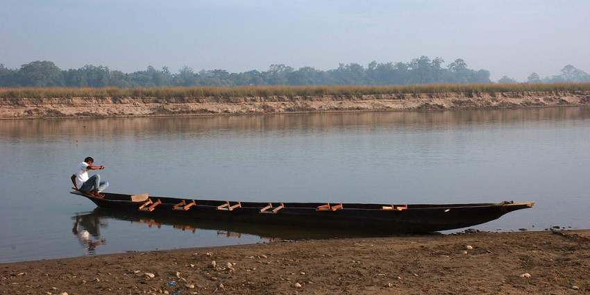 A boat navigating the serene waters of Royal Chitwan National Park in Nepal