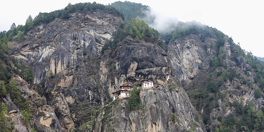 Panoramic view of Taktsang Monastery perched above the lush Paro Valley in Bhutan.