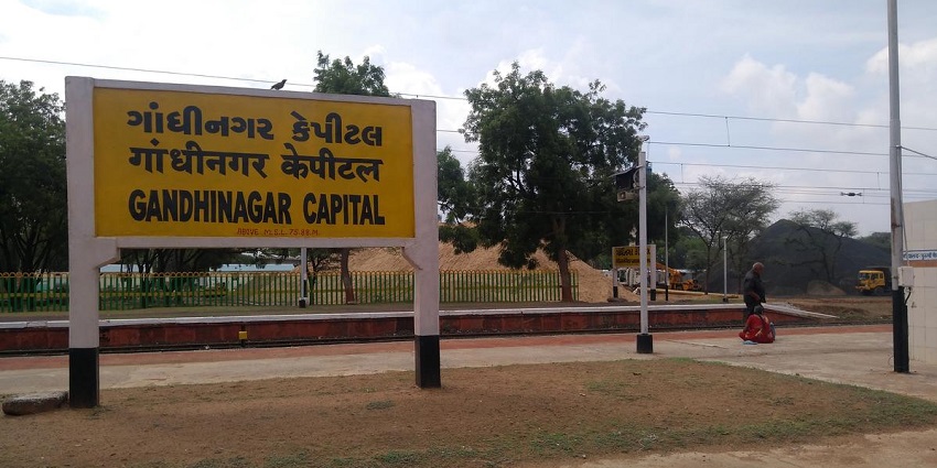 Gandhinagar railway station with modern architecture and bustling activity.