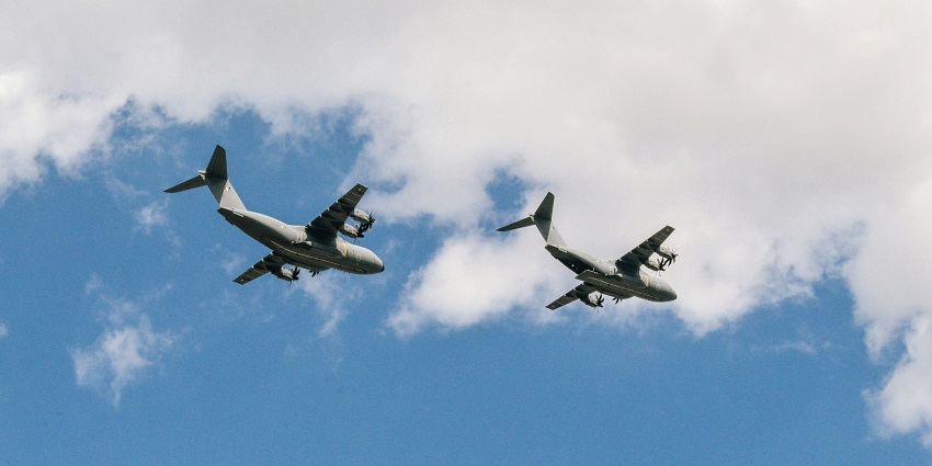 A breathtaking view of two white aeroplanes in the clear blue sky during the daytime.