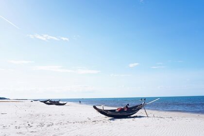 An enchanting view of pristine sands decked with boats and serene waters of the beach.