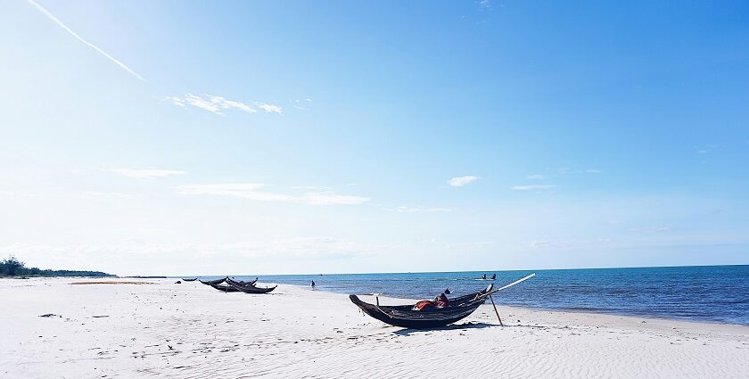 An enchanting view of pristine sands decked with boats and serene waters of the beach.