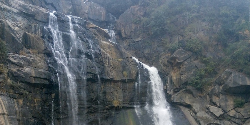 The majestic Hundru Falls cascade down rocky cliffs surrounded by nature.