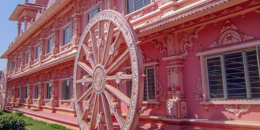 A picture of a wall of the ISKCON Anantapur Temple with a wheel carved onto the wall