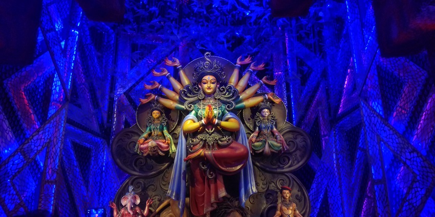 The Idol of Goddess Durga with other Gods and Goddesses is placed on a bluish background