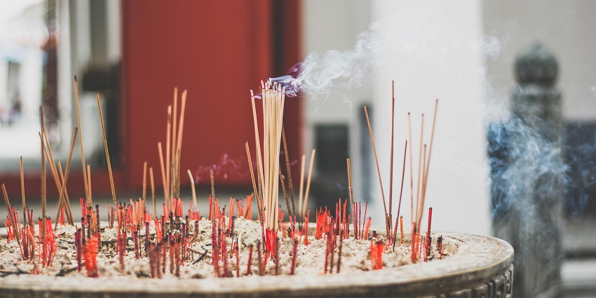 Incense sticks resting on grey ashes, creating a serene and calming atmosphere.