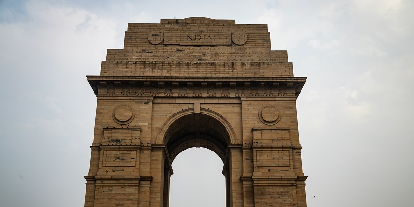 A glimpse of the towering India Gate standing against the backdrop of clear skies.