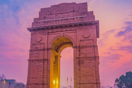 Evening view of India Gate, illuminated against a twilight sky - nightlife in Delhi.