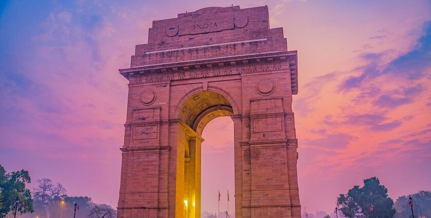 Evening view of India Gate, illuminated against a twilight sky - nightlife in Delhi.