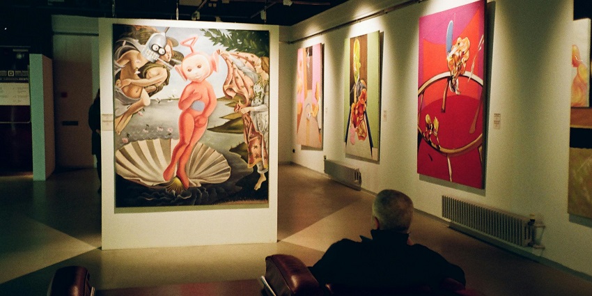 A man looking at the paintings in the art gallery of on of the museums in Raipur.