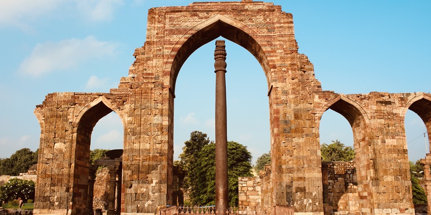 The Iron Pillar of Delhi standing tall with ancient inscriptions and weathered surface