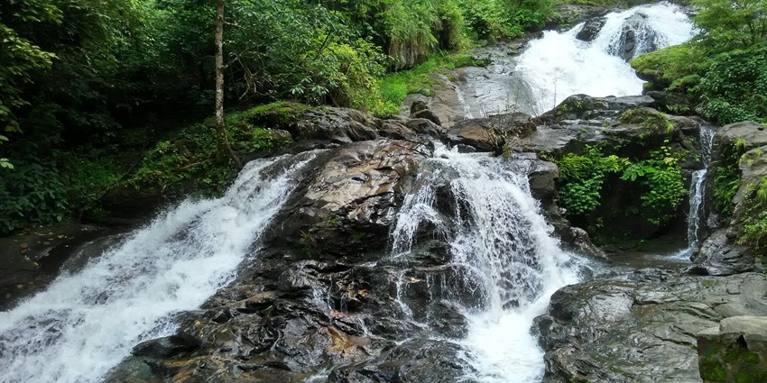The water falls through the rocks, enclosed by lush greenery, near Nagarhole National Park