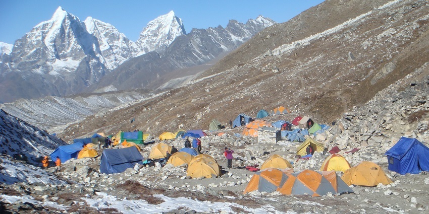 Island Peak Base Camp with climbers, surrounded by high-altitude mountains in Nepal.
