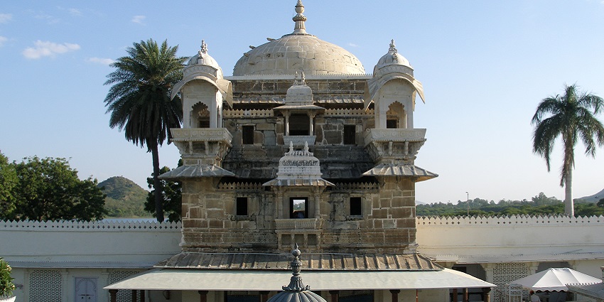 The Jag mandir features marble sculptures and lush green surroundings.