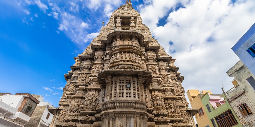 The intricate stone carvings of Jagdish Temple standing tall against a clear October sky in Udaipur.