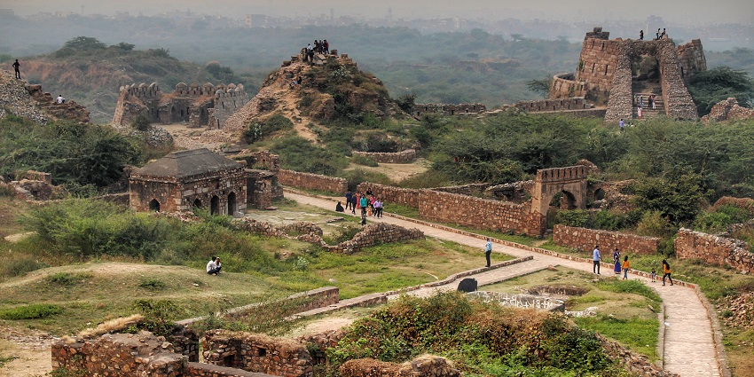 An aerial picture of a monument with traditional designs and intricate architecture, surrounded by greenery