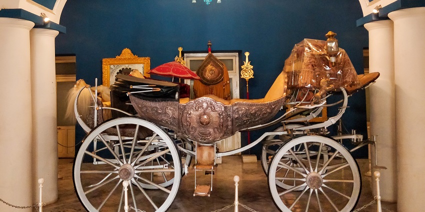 A traditional cart is displayed outside Jai Vilas Palace in Gwalior, one of the top places to visit in Gwalior.