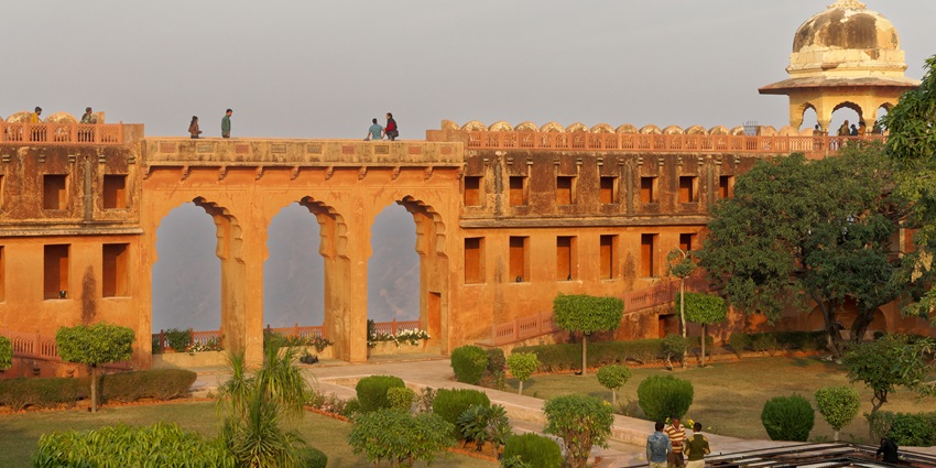 Wide angle view of the Jaigarh Fort, with the clear blue sky in the background and lush trees all around.