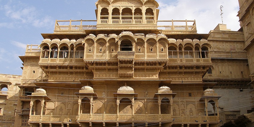 The ornate sandstone facade of a haveli featuring intricate carvings and architectural details.