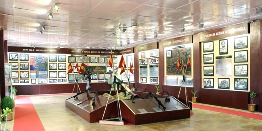 Panoramic view of Laungewala Hall at Jaisalmer War Museum with displayed military vehicles.