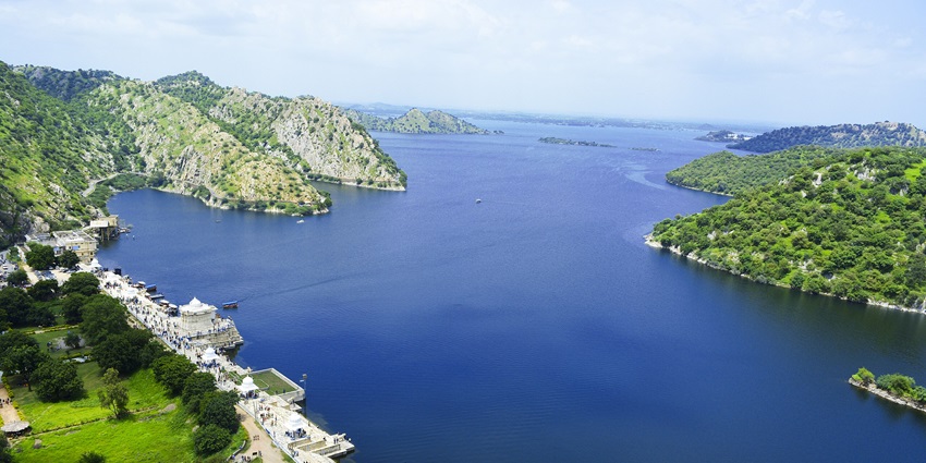 Scenic Jaisamand Lake embraced by lush hills, offering a breathtaking view to visitors