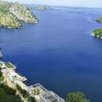 A serene view of Jaisamand Lake, surrounded by the dense greenery of Jaisamand Wildlife Sanctuary