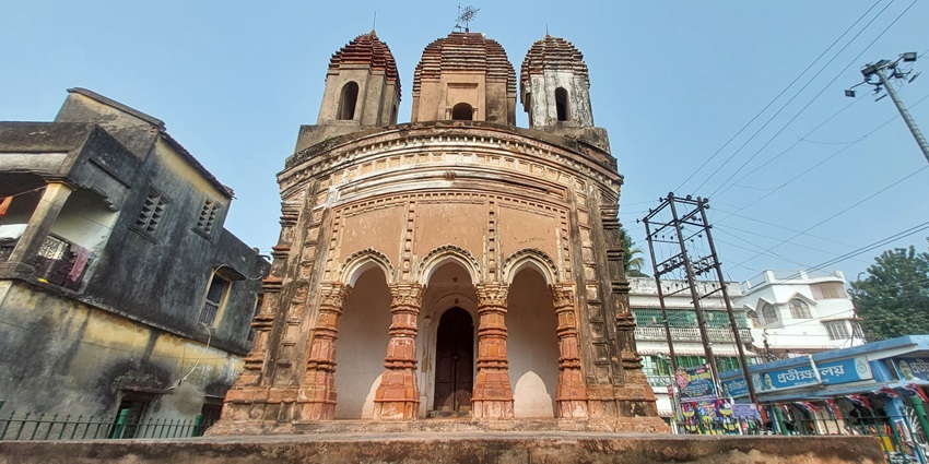 A frontal view of a historical temple in Janakpur with intricate wall carvings and a traditional built