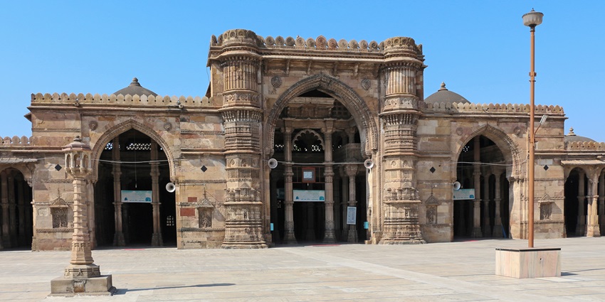 Jama Masjid with its grand arches, intricate carvings, and vast courtyard under a clear sky