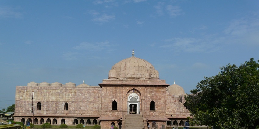 Grand Jami Masjid with intricate arches, stone pillars, and a peaceful courtyard view.