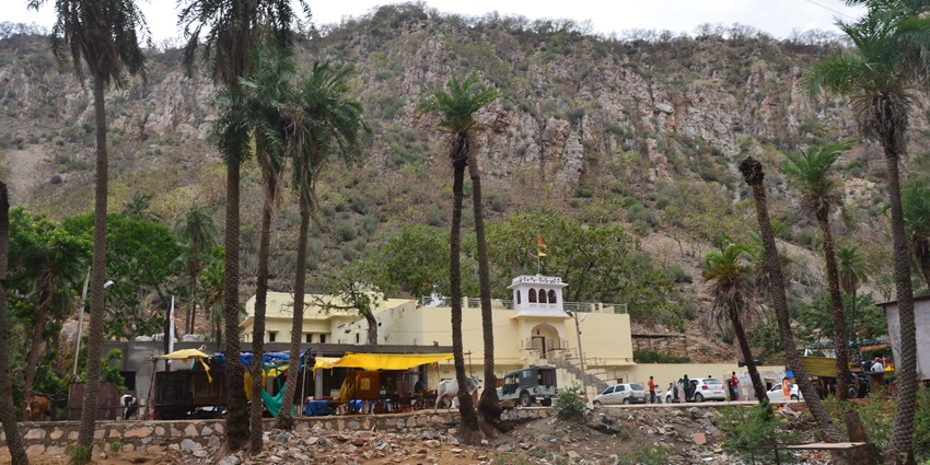 A frontal view of a temple with lush surroundings, located near Jamwa Ramgarh Wildlife Sanctuary