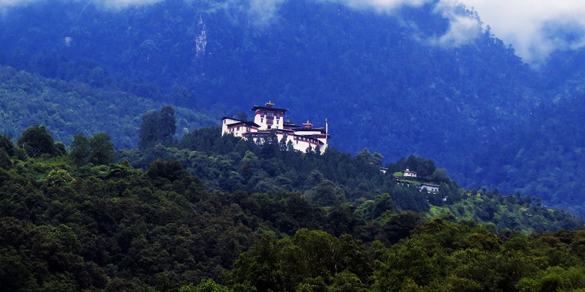 Panoramic view of Gasa Dzong, nestled in the lush green mountains of Jigme Dorji National Park.