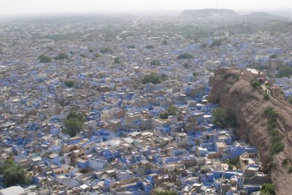 Panoramic view of Jodhpur's cityscape with forts and blue-painted buildings.