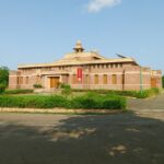 The outside view of a Jodhpur museum, Surrounded by greenery and a beautiful garden area.