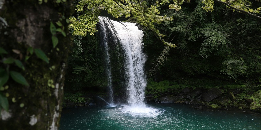 A scenic view of shimmering waters cascading down and merging the river beneath.