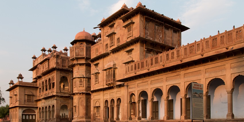 Image of an expansive view of the majestic Junagarh Fort during sunset with sun reflection