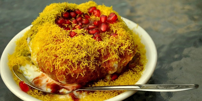 Raj kachori, served with multiple chutneys and garnished with sev and curd