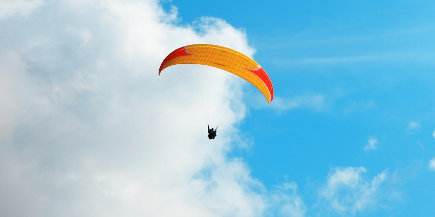 A mesmerising view of a person enjoying an aerial activity with clouds in the background.