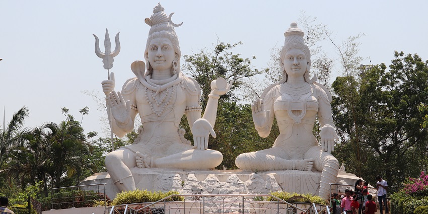 A picture of a tall statue of Lord Shiva and Goddess Parvati in the centre of a park in Visakhapatnam