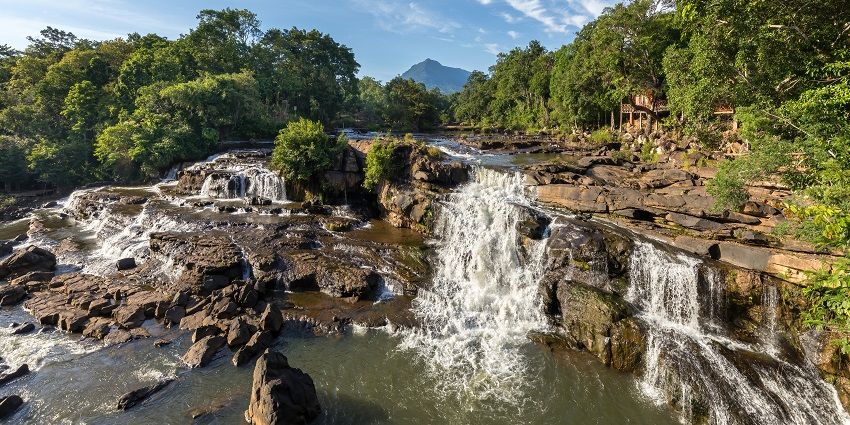 A picture of a famous waterfall in Visakhapatnam with mountains in the background