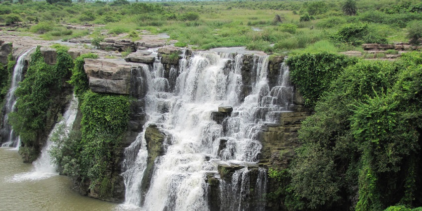 Enchanting view of silver water cascading down the rocks surrounded by lush greenery