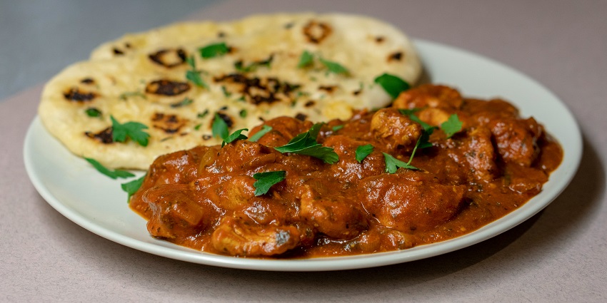 A plate featuring roti, sliced meat, and a rich sauce, beautifully arranged - best food in chandni chowk